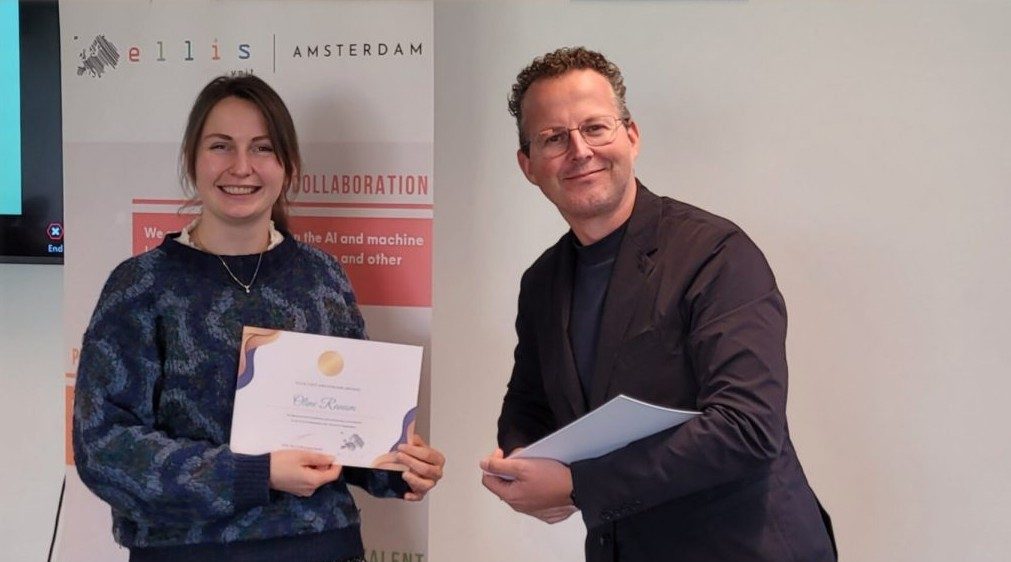 Oline Ranum receiving an ELLIS Amsterdam certificate in front of an ELLIS Amsterdam banner